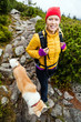 Woman hiking in mountains and walking akita dog