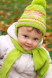 Smiling baby girl closeup portrait in hat looking on outdoor aut