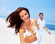 Young woman with her boyfriend having fun at the beach