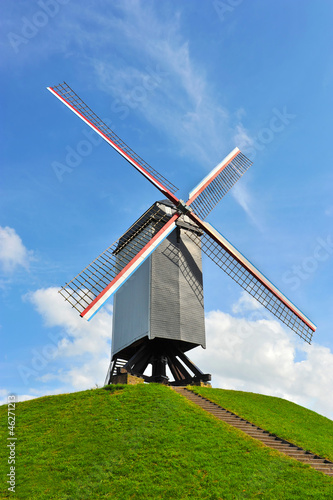 Photo: Dutch windmill on green hill with blue sky ( Holland ) Dutch windmill on green hill with blue sky ( Holland )