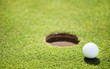 golf ball on lip of cup