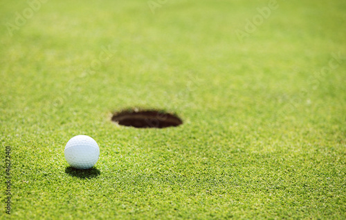 Photo: golf ball on lip of cup golf ball on lip of cup