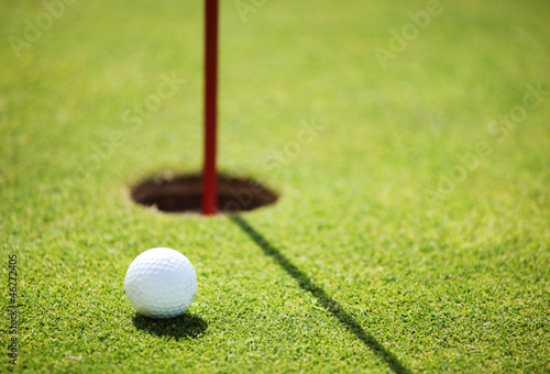 Photo: golf ball on lip of cup golf ball on lip of cup