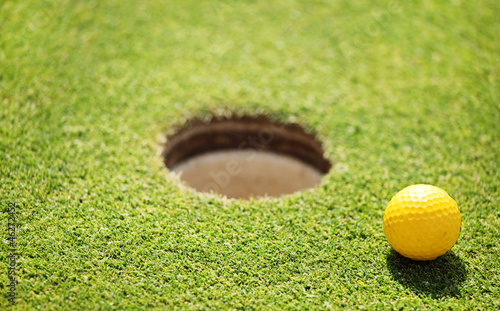 Photo: golf ball on lip of cup golf ball on lip of cup