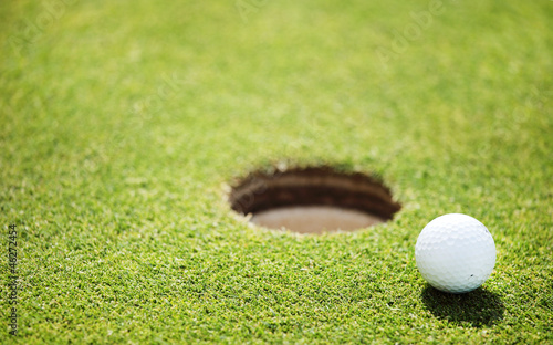 Photo: golf ball on lip of cup golf ball on lip of cup