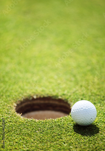 Photo: golf ball on lip of cup golf ball on lip of cup