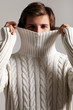 man in sweater protecting his neck and face from a cold