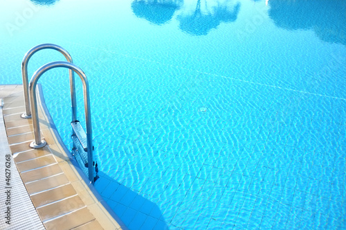 Photo: Hotel swimming pool with sunny reflections. Hotel swimming pool with sunny reflections.