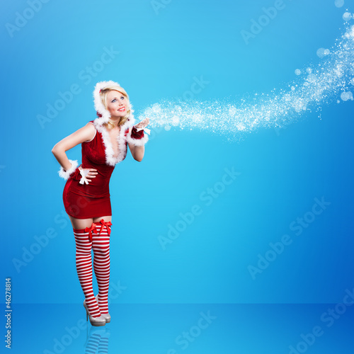 Photo: Weihnachtsfrau im roten Minikleid vor blauem Hintergrund Weihnachtsfrau im roten Minikleid vor blauem Hintergrund