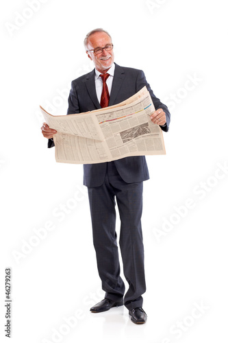 Photo: Standing senior business man reading newspaper Standing senior business man reading newspaper