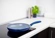 Frying pan in modern kitchen with induction stove