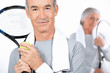 Elderly couple playing tennis together