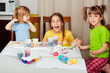 Photo: Three little girls (sisters) painting on Easter eggs Three little girls (sisters) painting on Easter eggs