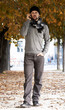 uomo che cammina su viale autunnale