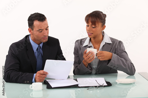 Photo: businessman and secretary consulting files businessman and secretary consulting files
