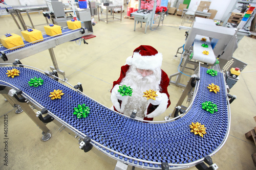 Photo: santa claus quality control manager at production line santa claus quality control manager at production line