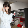 Young woman phoning at home, by the kitchen