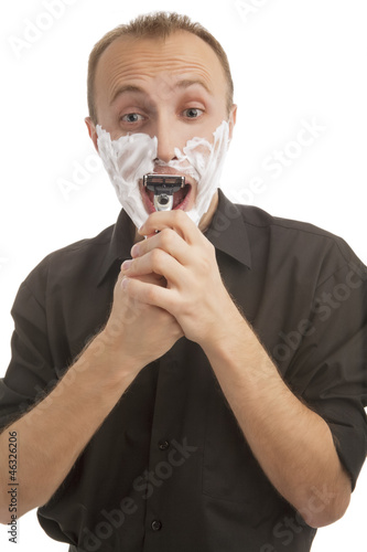 Photo: portrait of a male trying to shave against white portrait of a male trying to shave against white