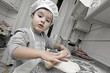 Foto: Pequeño cocinero preparando una masa de pan en la cocina Pequeño cocinero preparando una masa de pan en la cocina