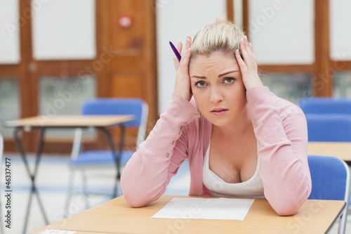 Photo: Woman looking worried over exam paper Woman looking worried over exam paper