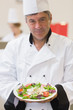 Foto: Cheerful chef presenting his salad Cheerful chef presenting his salad