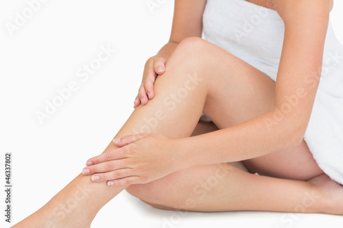 Photo: Woman sitting touching her legs Woman sitting touching her legs