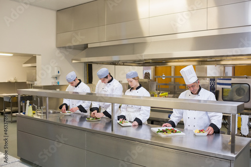Photo: Four Chef's preparing plates Four Chef's preparing plates
