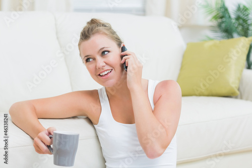 Photo: Woman phoning while drinking coffee Woman phoning while drinking coffee