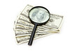 Magnifying glass resting on dollars