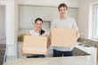 Photo: Young man and woman holding moving boxes Young man and woman holding moving boxes