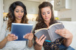 Photo: Girls reading a book and holding a tablet computer Girls reading a book and holding a tablet computer