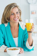 Photo: Woman having juice and cereal for breakfast Woman having juice and cereal for breakfast