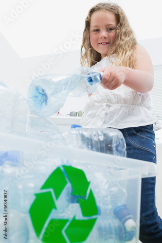Photo: Girl throwing bottles into recycling box Girl throwing bottles into recycling box