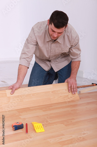 Photo: Man installing laminate flooring Man installing laminate flooring
