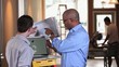 Vidéo : Architect and small business owner discussing plans and using laptop inside building under construction Architect and small business owner discussing plans and using laptop inside building under construction