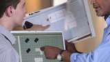 Video: Architect and small business owner discussing plans and using laptop inside building under construction Architect and small business owner discussing plans and using laptop inside building under construction