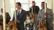 Group of smiling businessmen in suits riding carousel horses