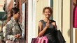 Women with shopping bags entering shop on urban street