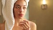 Mixed race woman applying lotion to her hands