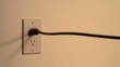 Plug is pulled, with sparks, from wall socket (slow motion)
