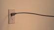 Power cord snakes into the frame and plugs into the wall socket (slow motion)