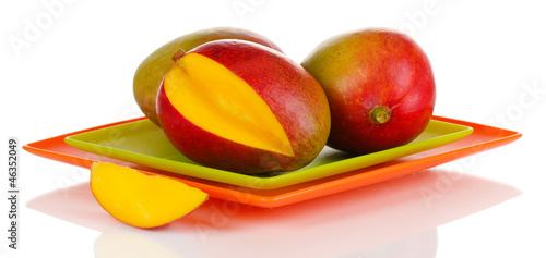 Photo: Ripe appetizing mango on red plate isolated on white Ripe appetizing mango on red plate isolated on white