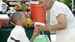 African American grandmother giving grandson orange juice