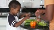 African American father with son preparing salad