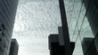 Clouds moving slowly across sky between two tall buildings