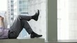 Caucasian businessman laying on a bench text messaging on cell phone