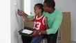 African American father with son painting wall