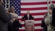 Political candidate with hands up addressing applauding crowd