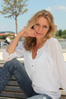 Woman with long blonde hair sitting on a bench