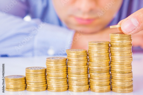 Photo: A Businessman rising coins A Businessman rising coins